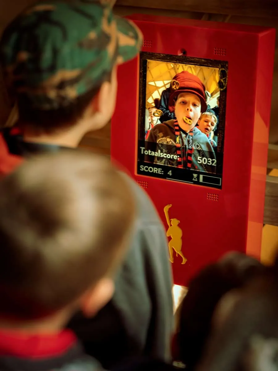Kinderen kijken naar een scherm met hun eigen beeld en een totaalscore.