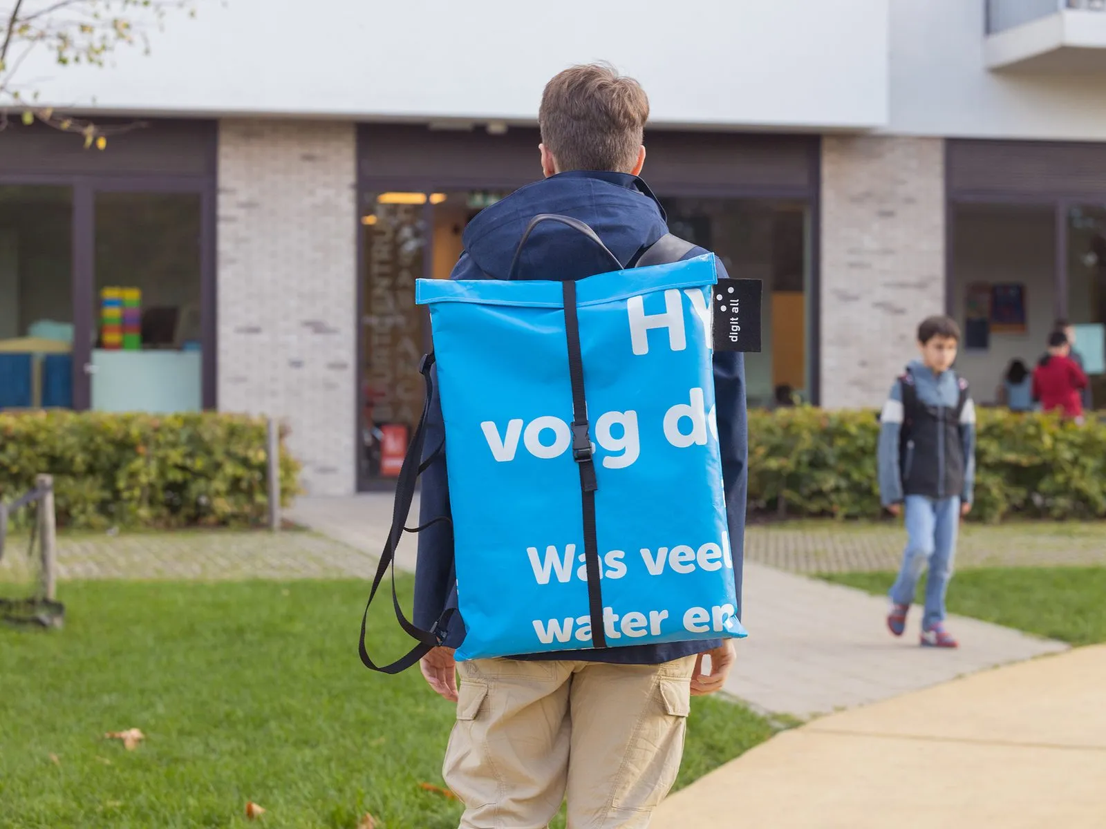 Iemand draagt het Hiveboard in een blauwe rugzak naar een dienstencentrum.