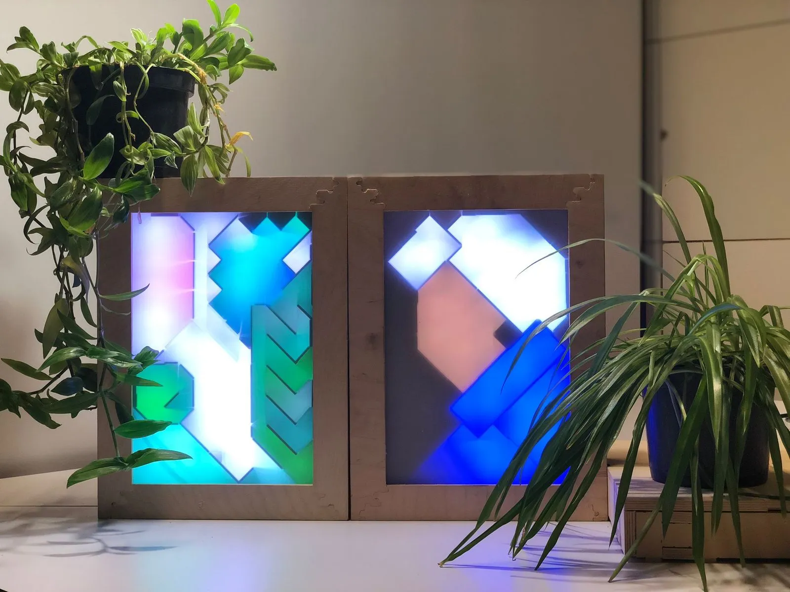 De Urban Species Lightbox: twee houten kaders met gekleurde, van achter verlichte geometrische vlakken.