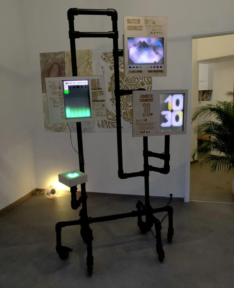 De mobiele unit binnen: een zwart buizenframe op wielen met schermen, panelen en een oplichtende knop.