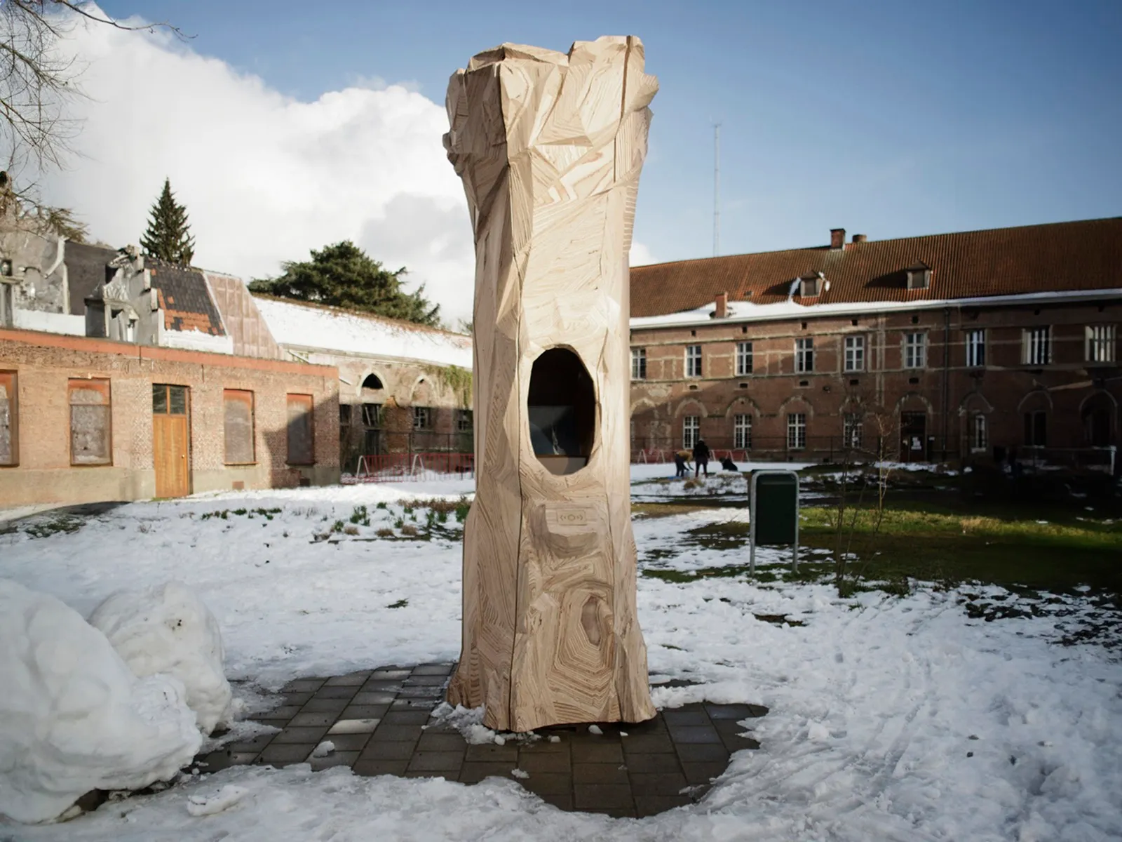 Dezelfde totem in de sneeuw, met de wijk op de achtergrond.